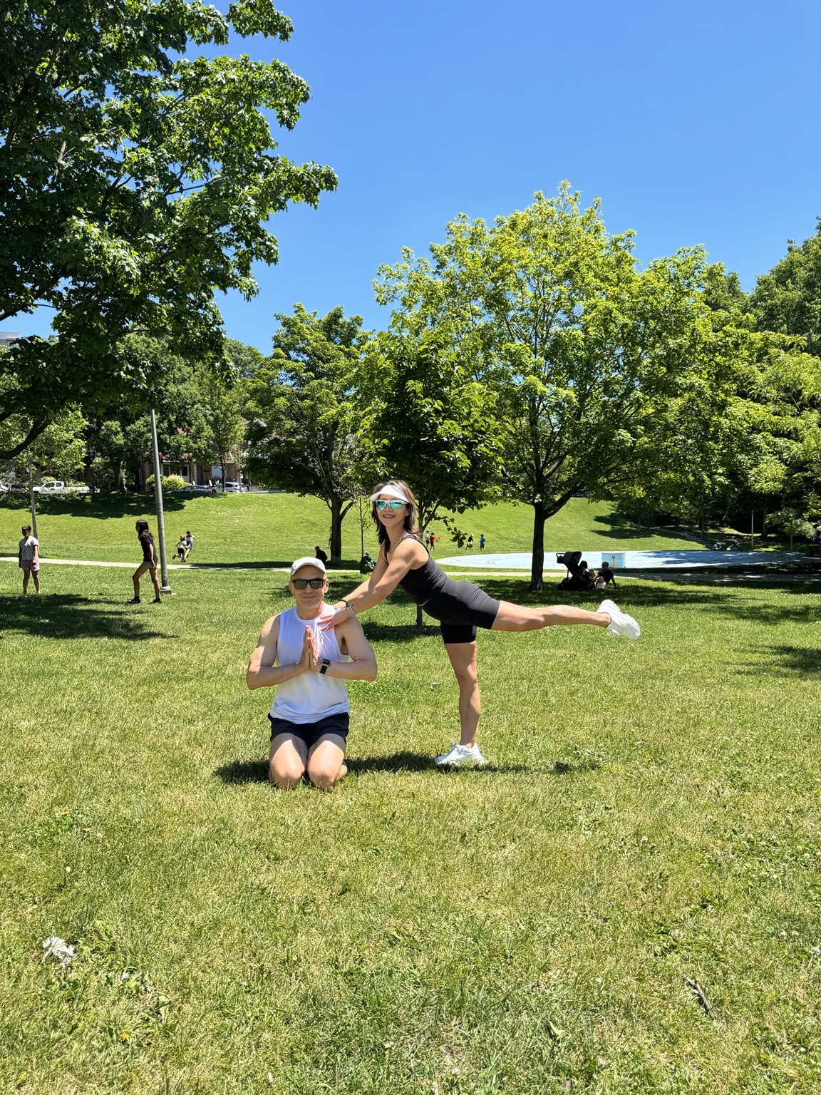 Lili balancing while Igor sits in a calm prayer pose in High Park