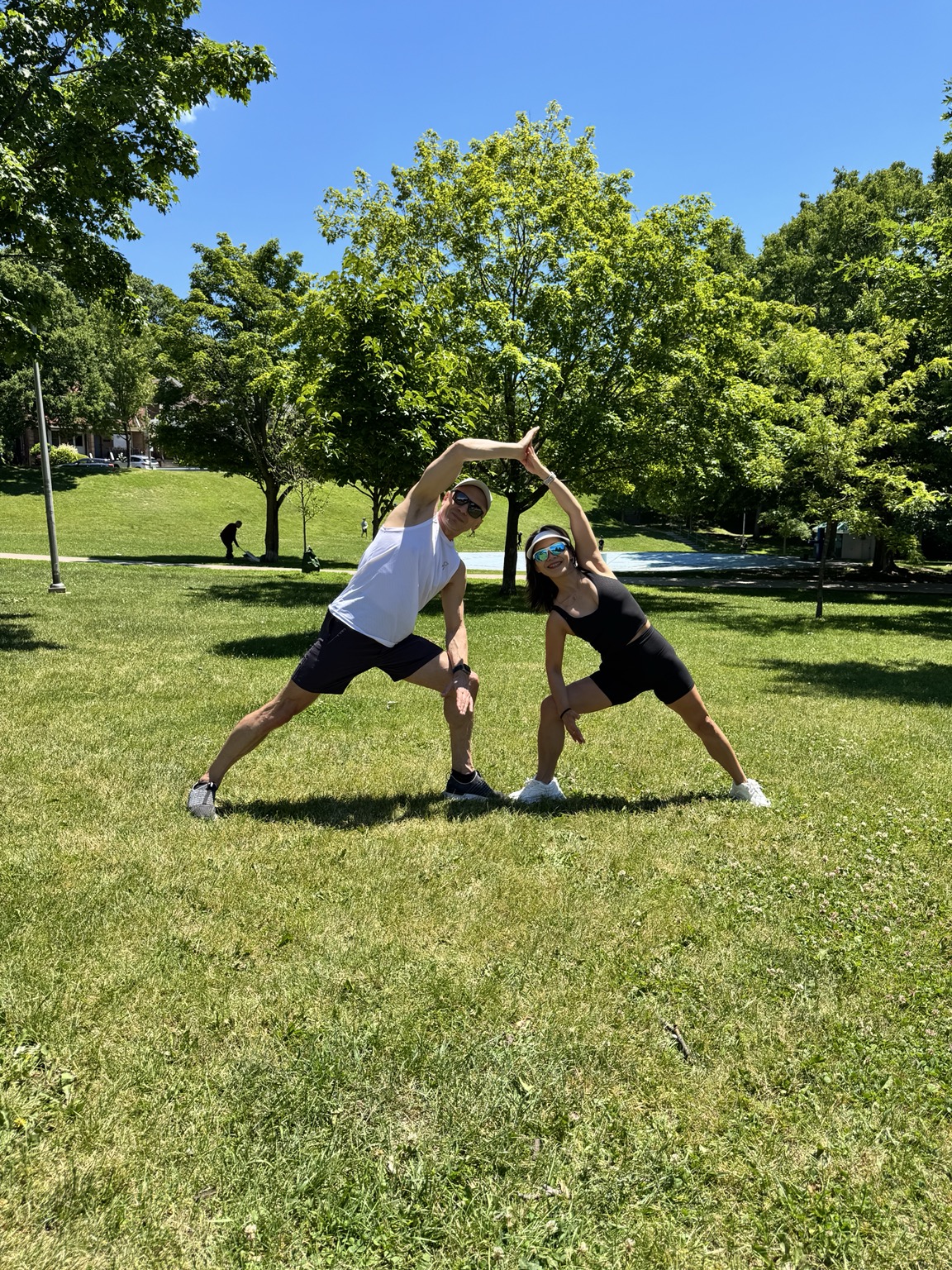 Lili and Igor sharing a standing side bend in High Park
